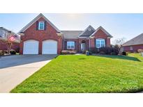 Charming brick home featuring a two-car garage, lush lawn, and manicured landscaping at 105 Plantation Ct, Shelby, NC 28150