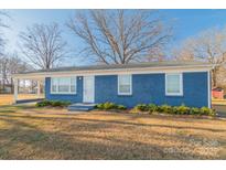 Ranch home features blue siding, covered porch, and a landscaped yard at 1127 Ansonville Rd, Wingate, NC 28174