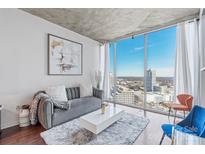 Stylish living room showcases floor-to-ceiling windows and a chic, contemporary design aesthetic at 210 N Church St # 2411, Charlotte, NC 28202