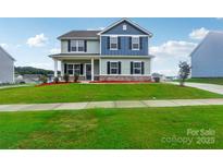 Two-story house with blue and green siding, landscaping, and a paved driveway at 3915 Allenby Pl, Monroe, NC 28110