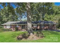 Brick ranch house with a large tree and well-maintained lawn at 401 Pine St, Fort Mill, SC 29715