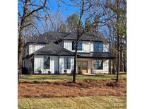 Stunning modern farmhouse with black trim, light wood accents, and a well-manicured lawn at 4605 Western Union School Rd, Waxhaw, NC 28173