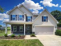 Charming two-story home with stone accents, a two-car garage, and a beautifully landscaped front yard at 4903 Greenloch Ct, Monroe, NC 28110