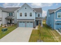 Two-story house with light blue siding, two-car garage, and a landscaped yard at 518 Switch St, York, SC 29745