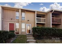 Two-story condo building exterior with landscaping and steps leading to the entrance at 7912 Charter Oak Ln, Charlotte, NC 28226