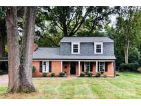 Charming brick home featuring a well-manicured front lawn and classic architectural details at 821 Greentree Dr, Charlotte, NC 28211