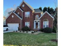 Charming two-story brick home with a well-manicured front lawn and attached two-car garage at 9010 Scottsboro Dr, Huntersville, NC 28078