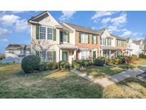 Charming townhomes featuring well-manicured lawns and beautiful green shutters and doors at 12584 Jessica Pl, Charlotte, NC 28269