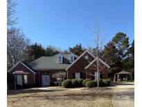 Charming brick home featuring well-manicured landscaping, mature trees, and a welcoming front entrance, gazebo in backyard at 13501 Misty Dew Ct # 19, Charlotte, NC 28273