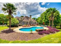 Resort style pool and patio area complete with lounge chairs and tropical landscaping in backyard of home at 1765 Old Clay Hill Rd, York, SC 29745