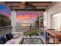 Beautiful balcony view, complete with ceiling fan, black iron railing, sunset view, and zebra rug at 17811 Half Moon Ln # E, Cornelius, NC 28031