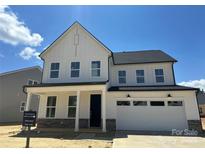 Modern two-story home with white siding, black roof, and an attached two-car garage at 4122 Eastover Glen Rd # 0316, Charlotte, NC 28269