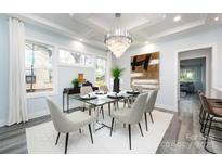 Bright dining room features a glass table, chandelier, and hardwood floors at 423 W Bell St, Statesville, NC 28677