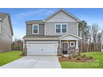 Two-story house with gray siding, white garage door, and landscaping at 4445 Dusty Orchard Rd, Kannapolis, NC 28081