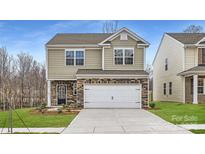 Two-story home featuring neutral siding, a two-car garage and a nicely landscaped front yard at 5725 Olive Beach Rd, Kannapolis, NC 28081