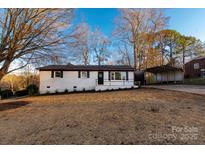Charming white brick home with a manicured lawn and a convenient covered carport at 3004 Briarwood Ln, Gastonia, NC 28056