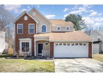 Two-story brick home with a tan facade, two-car garage, and landscaping at 3316 Brooktree Ln, Indian Trail, NC 28079