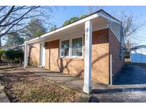 Brick ranch home with a covered porch and driveway at 3721 Braden Dr, Charlotte, NC 28216