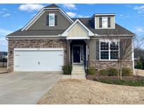 Charming two-story home with stone accents, a two-car garage, and professionally landscaped yard at 8906 Powder Works Dr, Huntersville, NC 28078