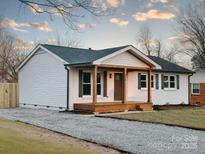 Charming white brick home featuring a wood porch and walkway, enhancing its curb appeal at 915 Tilden Rd, Charlotte, NC 28214