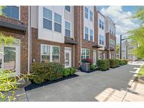 Modern brick townhome with manicured landscaping and walkway to front door at 232 Parkwood Ave, Charlotte, NC 28206