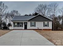 Charming single-story home with gray siding, a paved driveway, and a well-maintained front yard at 3608 Shadowcrest Dr, Concord, NC 28027