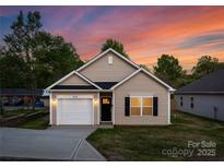 Charming single-story home with a one-car garage, complemented by a well-maintained lawn and inviting facade at 406 Killian Ave, Mount Holly, NC 28120