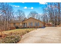 Ranch style home with a spacious driveway and mature trees at 906 Harmony Dr, Statesville, NC 28677
