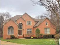 Charming two-story brick home featuring well-manicured landscaping and a classic architectural design at 11402 Bloomfield Dr, Charlotte, NC 28277