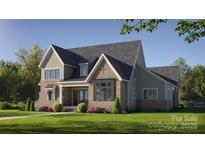 Charming two-story home with brick facade, manicured lawn and colorful shrubbery under a sunny sky at 1437 Samuel Spencer Pkwy, Davidson, NC 28036