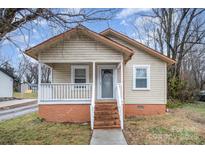 Charming single-story home featuring a cozy front porch and natural light from the large windows at 207 S Caldwell Ave, Newton, NC 28658