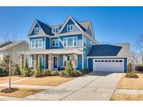 Beautiful two-story blue home with an attached garage and a well-maintained lawn and landscaping at 520 Crawfish Dr, Fort Mill, SC 29708