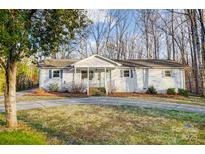 Charming white brick home featuring a welcoming front porch and a well-maintained front yard at 6017 Caroline Dr, Matthews, NC 28104