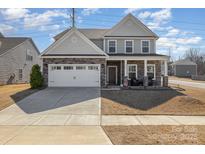 Charming two-story home with a stone and siding facade, two car garage and a well-maintained front yard at 7019 Lenton Rd, Charlotte, NC 28215