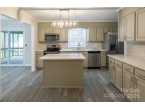 Updated kitchen with island, stainless steel appliances, and light cabinets at 833 E Chestnut St, Stanley, NC 28164