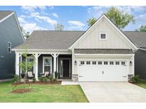 Charming home featuring a covered porch, well-manicured lawn, and an attached two-car garage at 119 Winterberry St, Mooresville, NC 28117