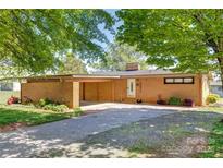 Charming brick ranch-style home with a covered carport and well-maintained landscaping in a suburban setting at 2004 Grandhaven Dr, Concord, NC 28027