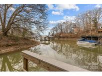Scenic lake view showcases a boat dock and covered boat slip, reflecting the sky on a tranquil day at 221 Island Terrace Rd, Statesville, NC 28677