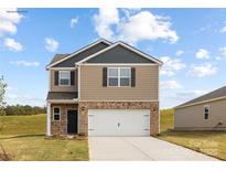 Charming two-story home featuring a brick and siding exterior, attached two-car garage, and a well-manicured lawn at 321 Brinkley Dr, Kings Mountain, NC 28086