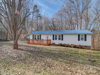 Charming home featuring a blue roof, new deck, and manicured landscaping at 1075 Fye Dr, Newton, NC 28658