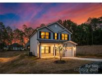 Charming two-story home with gray siding, black shutters, and a well-manicured lawn at dusk at 1116 Thayer Glen Ct, Charlotte, NC 28213