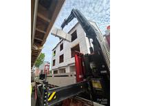 Construction site showing crane lifting wall paneling of new three-story townhouse complex at 115 Verbena Ne St # 12, Charlotte, NC 28217