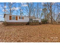 Single-wide mobile home with wood deck and wooded lot at 1789 Paris Dr, Conover, NC 28613