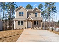 Charming two-story home with neutral siding and a concrete driveway offers curb appeal at 2204 Hillcrest Ave, Albemarle, NC 28001