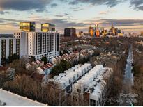 Stunning aerial view of a neighborhood with modern condos and the city skyline at sunset at 287 Mcdonald Ave, Charlotte, NC 28203