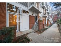 Townhouse exterior featuring a brick and gray wood facade, small balconies, and front door at 287 Mcdonald Ave, Charlotte, NC 28203