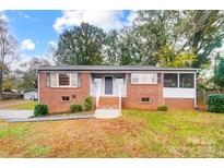 Brick ranch home with a screened porch and well-manicured lawn at 403 Little St, Lincolnton, NC 28092