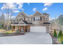 Beautiful two-story home with a brick and siding exterior, a two-car garage and a well-manicured front yard at 4114 Thames River Pl, Harrisburg, NC 28075