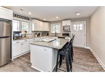 Bright, open kitchen with white cabinets, stainless steel appliances, and an eat-in island at 7514 Highway 205 Hwy, Marshville, NC 28103
