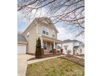 Charming two-story home featuring a welcoming front porch and well-maintained landscaping at 7602 Rolling Meadows Ln, Huntersville, NC 28078